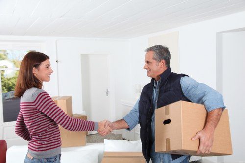 Packed moving boxes and furniture ready for transport by Colliers Wood movers