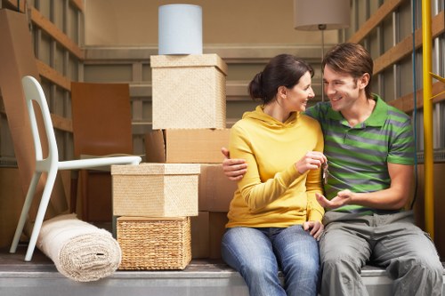 Professional movers loading wooden furniture into removal van